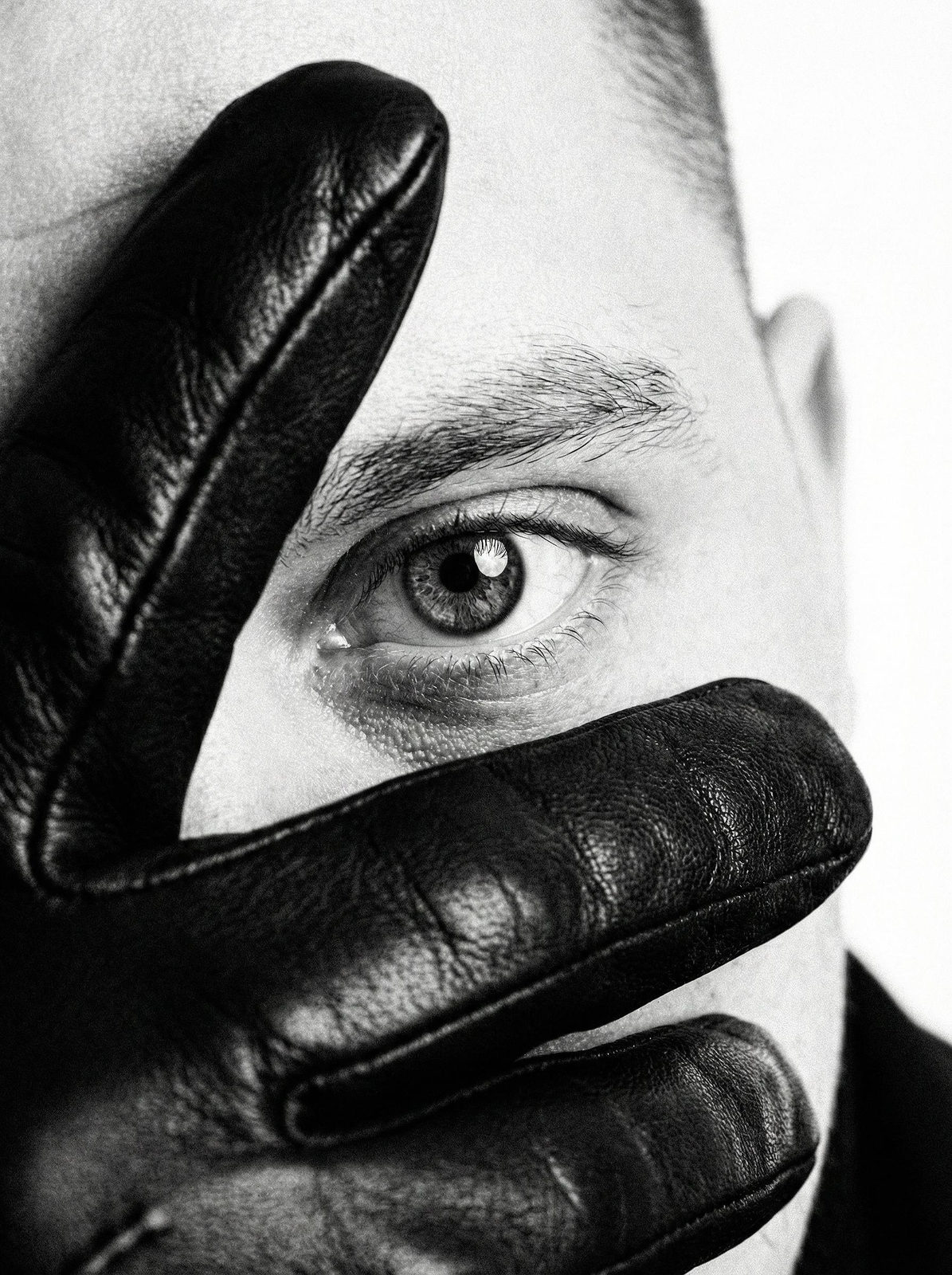 Extreme close-up of a brutal gaze, showcasing a focused eye through leather glove.