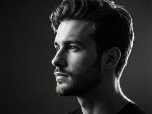 A striking black and white side-profile portrait against a smooth backdrop, showcasing fine facial contours.