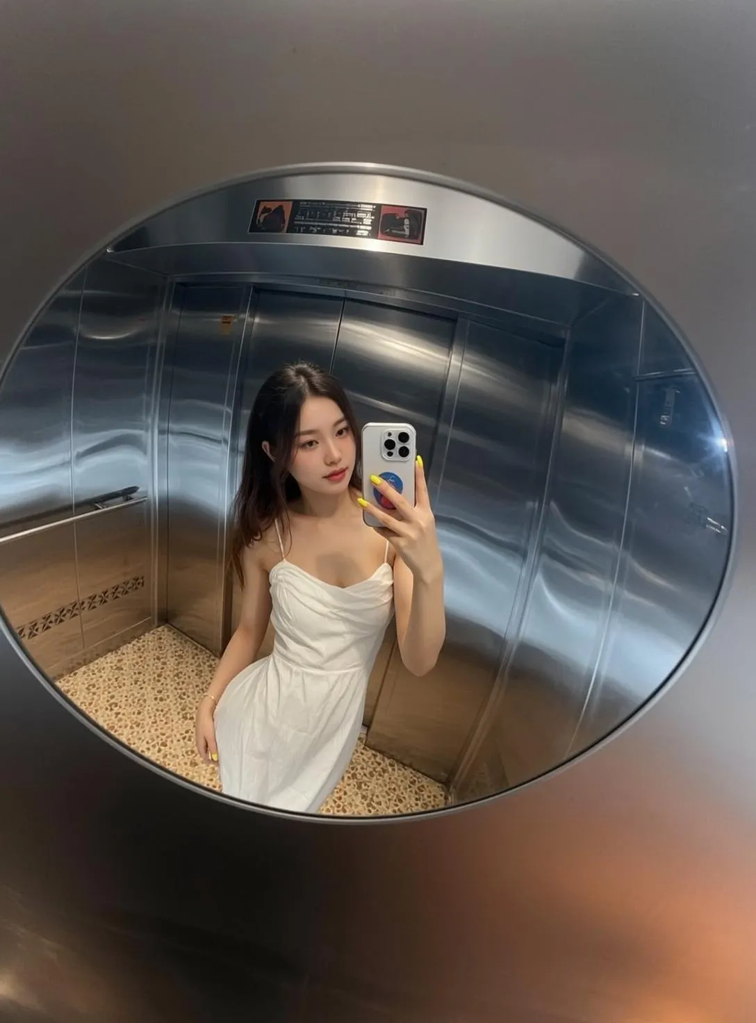 White Dress Holding Phone In Elevator Mirror