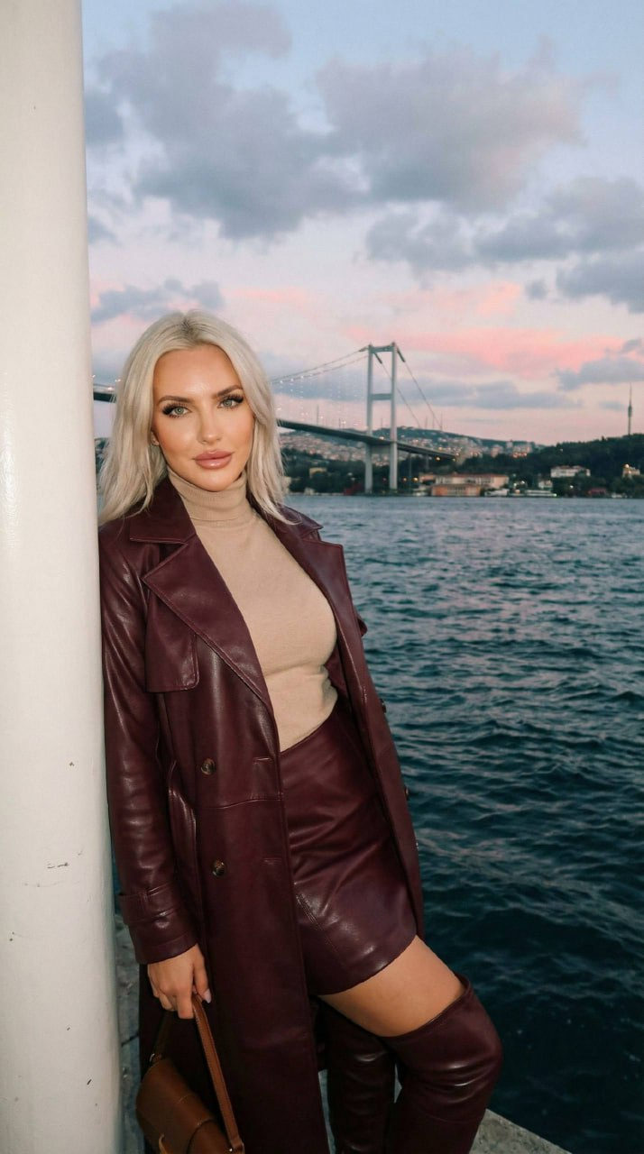 A photorealistic girl leaning against a column at twilight by the Bosphorus Bridge, wearing a deep wine leather coat and mini-skirt.
