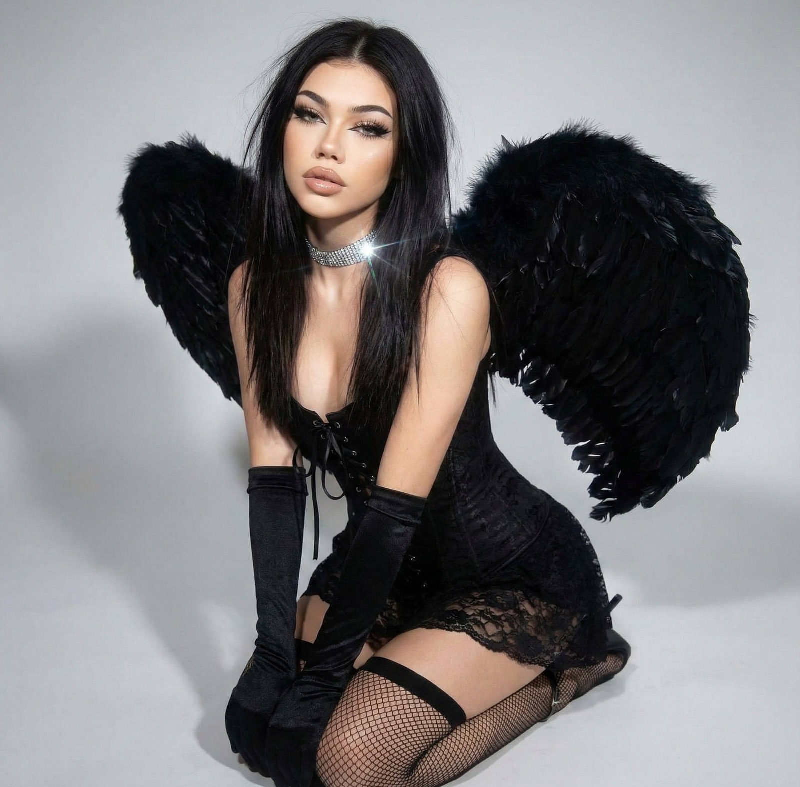 A glamorous dark angel in a black corset top and lace skirt, kneeling with a confident gaze and long black wings.