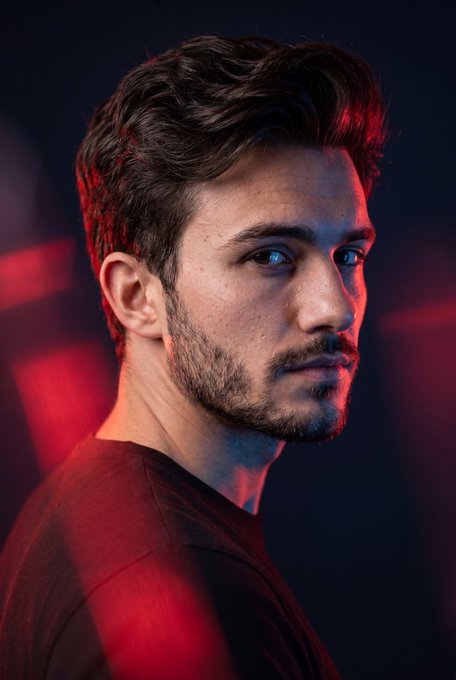 A close-up side profile portrait featuring vibrant red light streaks highlighting hair and jawline against a dark background.