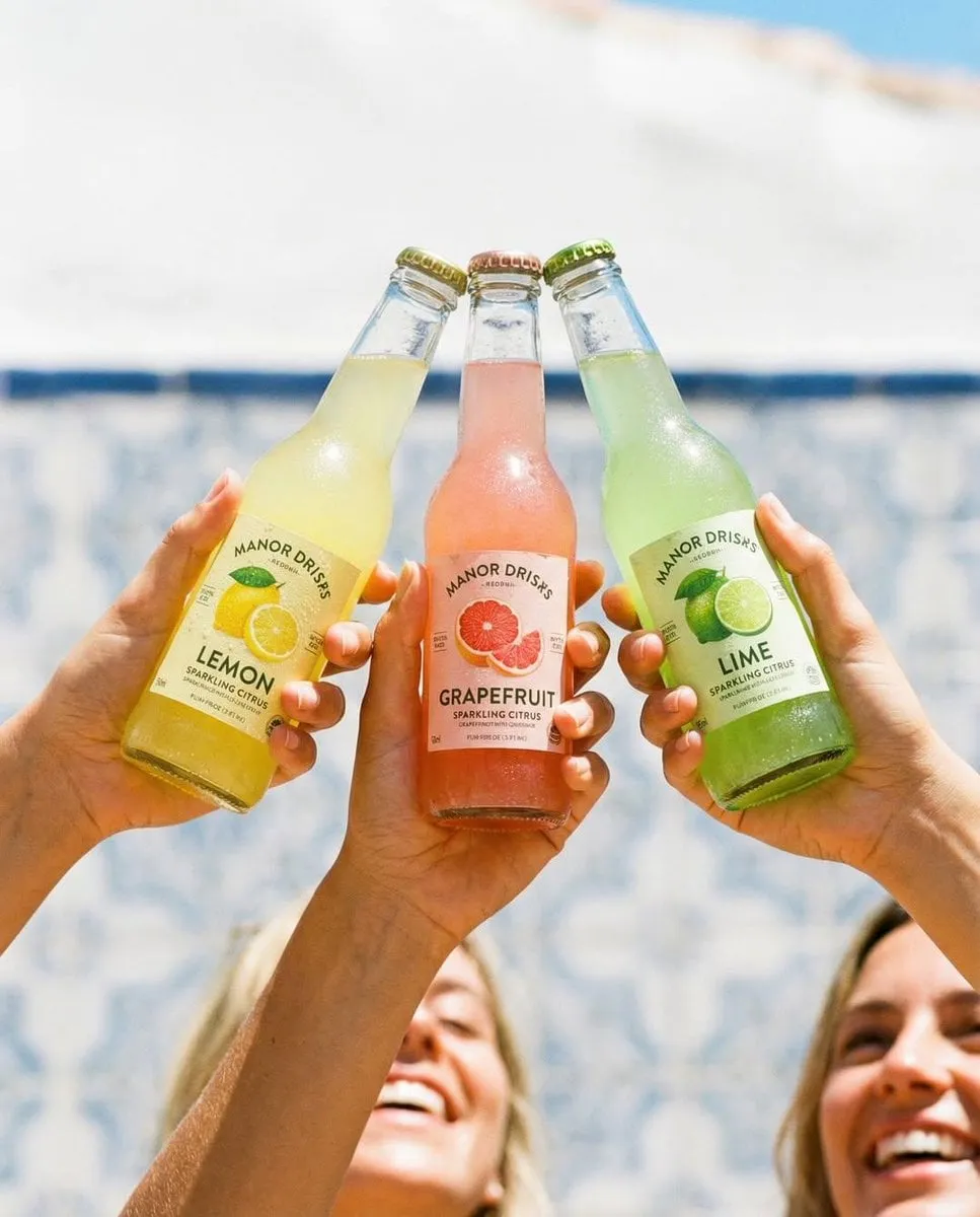 Hands Clinking Soda Bottles Bright Sunny Outdoor Setting