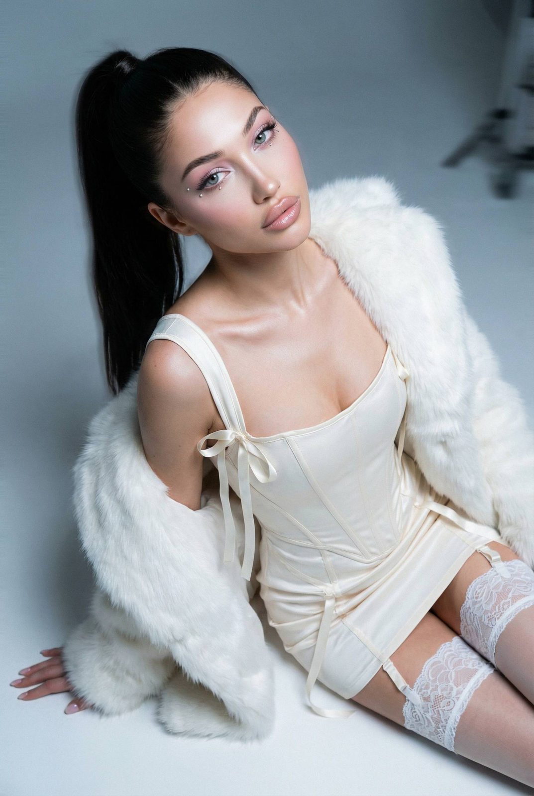 A cinematic portrait of a young woman in an ivory corset dress, seated on the floor with an elegant pose and soft faux-fur stole.