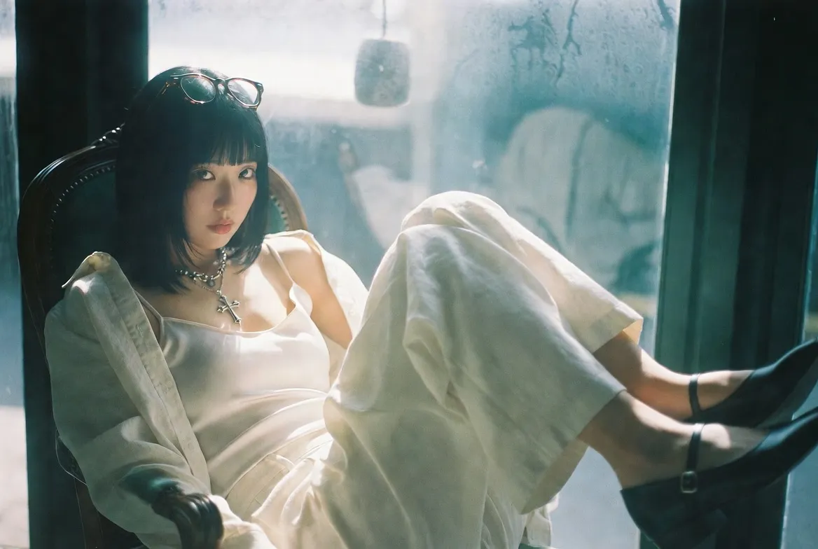 Thick Frame Glasses And Cross Necklace By A Window