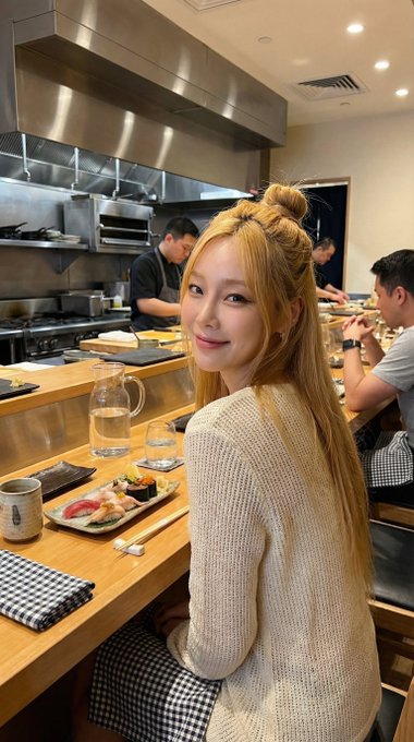 A girl in a gingham dress smiling at the camera in a ramen shop, with soft warm lighting creating an inviting atmosphere.