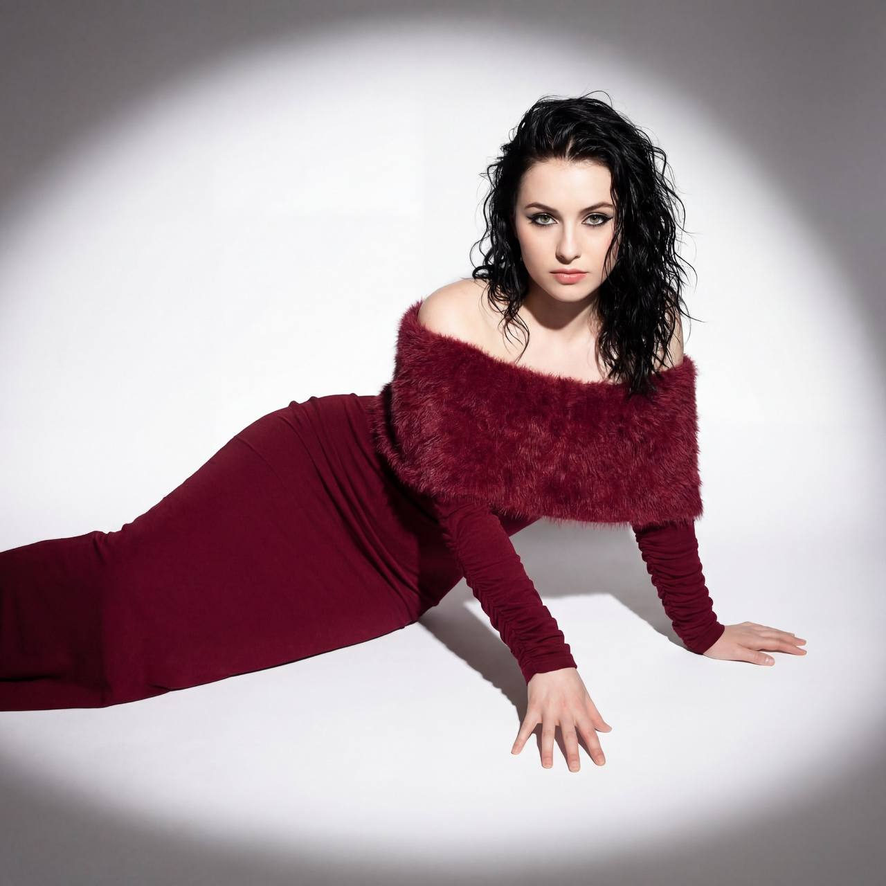 A serene woman lying like a statue, dressed in a wine-colored gown, embodying grace and confidence.