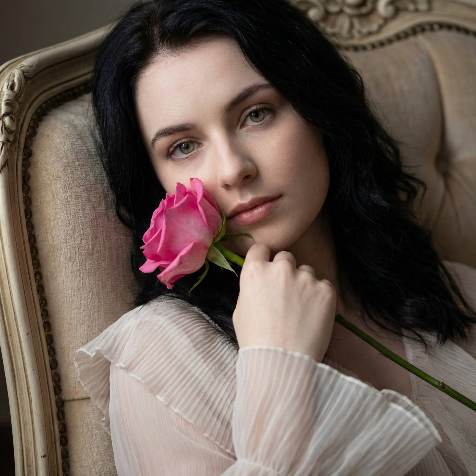 A close-up portrait of a woman holding a bright pink rose to her face, illuminated softly, conveying intimacy and elegance.