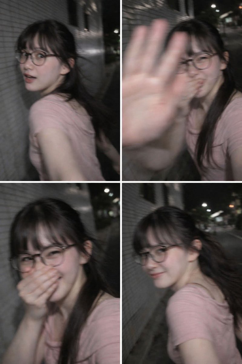 A woman walking on a Tokyo sidewalk, turning back with a shy smile, her hand partially blocking the camera, captured in motion blur.