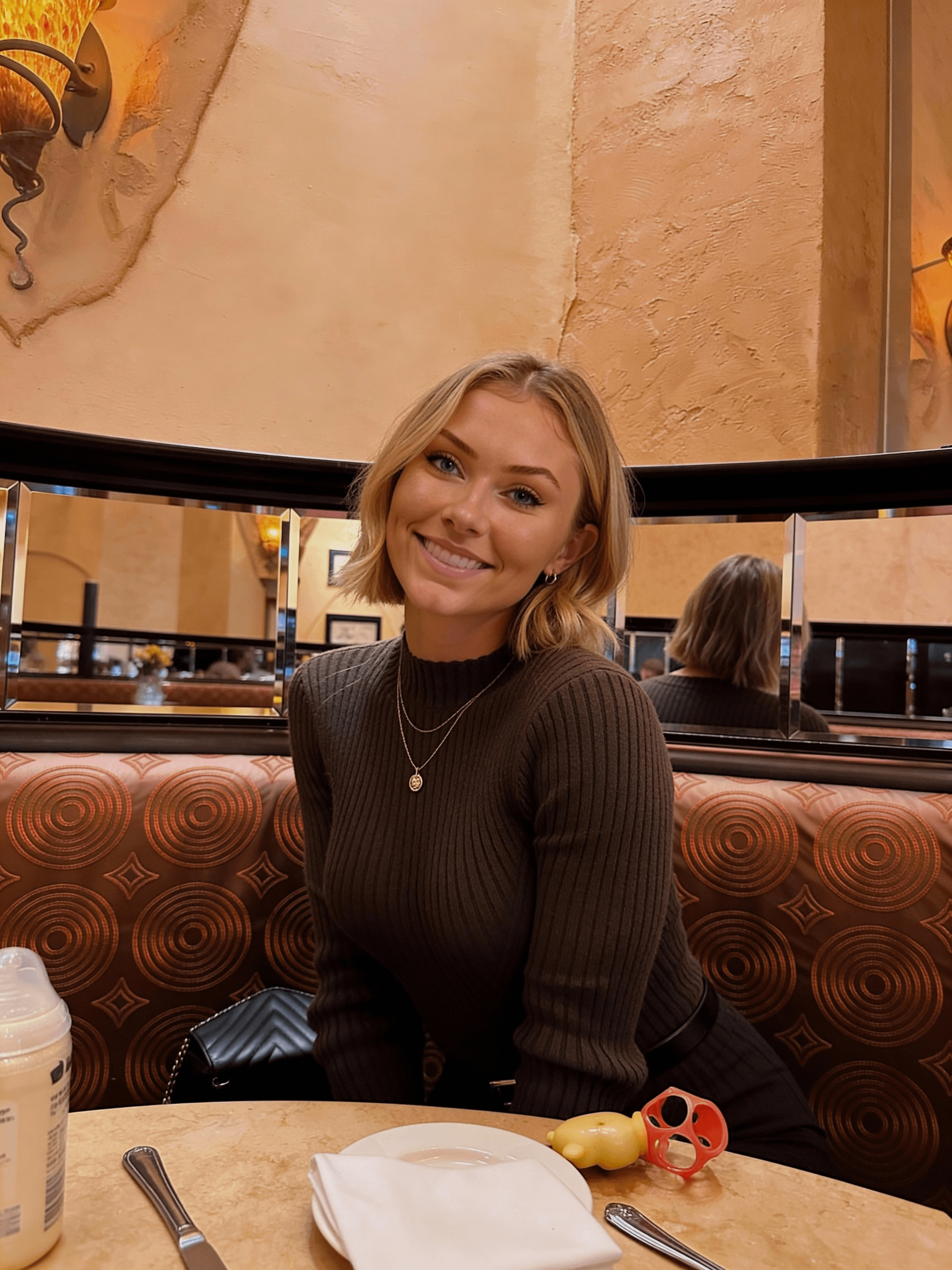 Seated At Restaurant Table Smiling