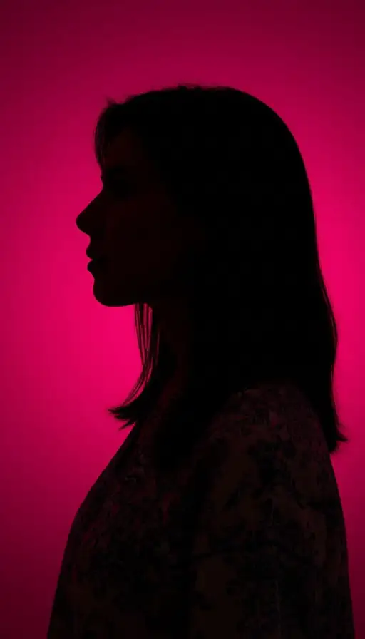 Profile silhouette of a woman against a vibrant hot pink backdrop, emphasizing the edge details.