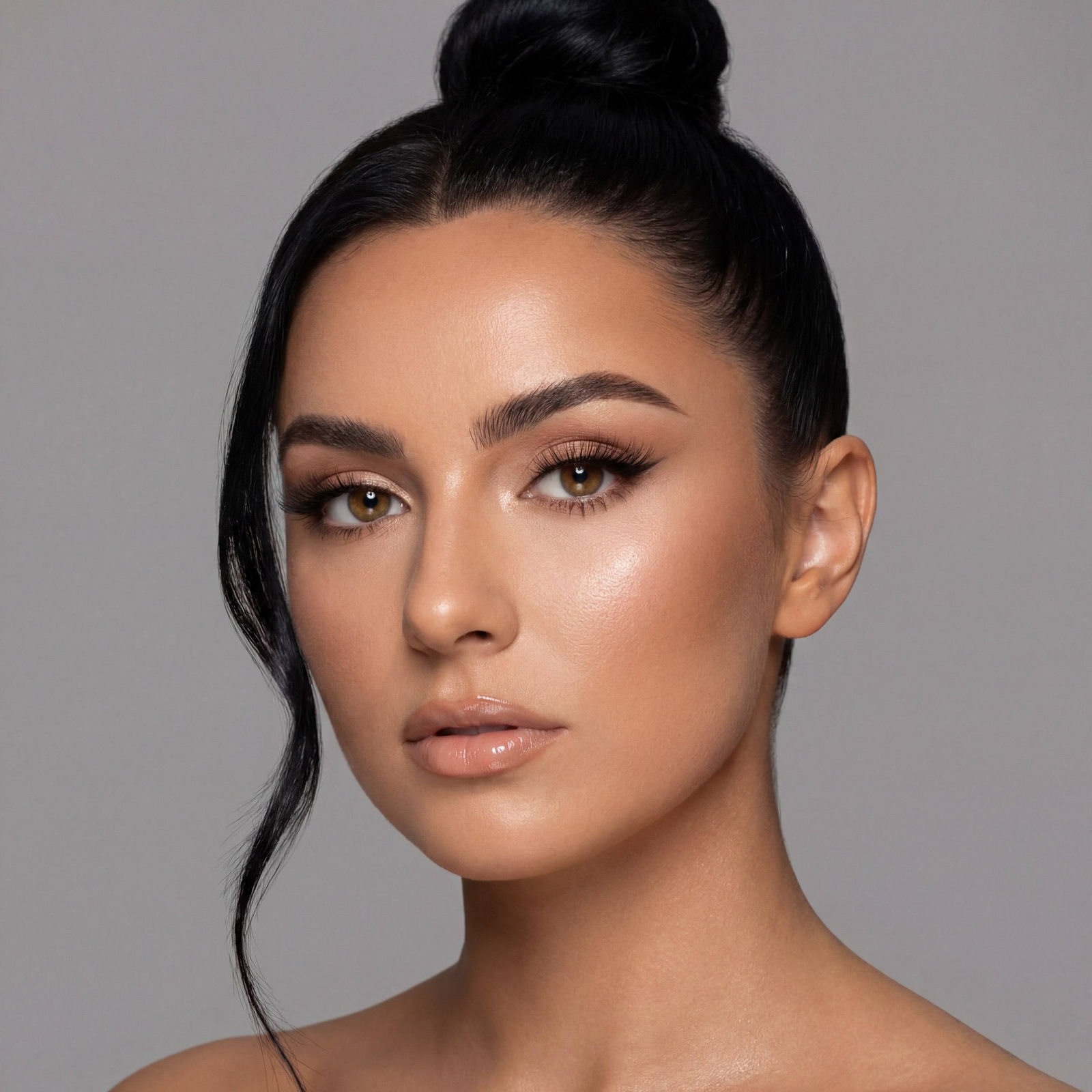 Ultra realistic beauty portrait of a woman with warm tan skin, glam makeup, and sleek high bun hairstyle.