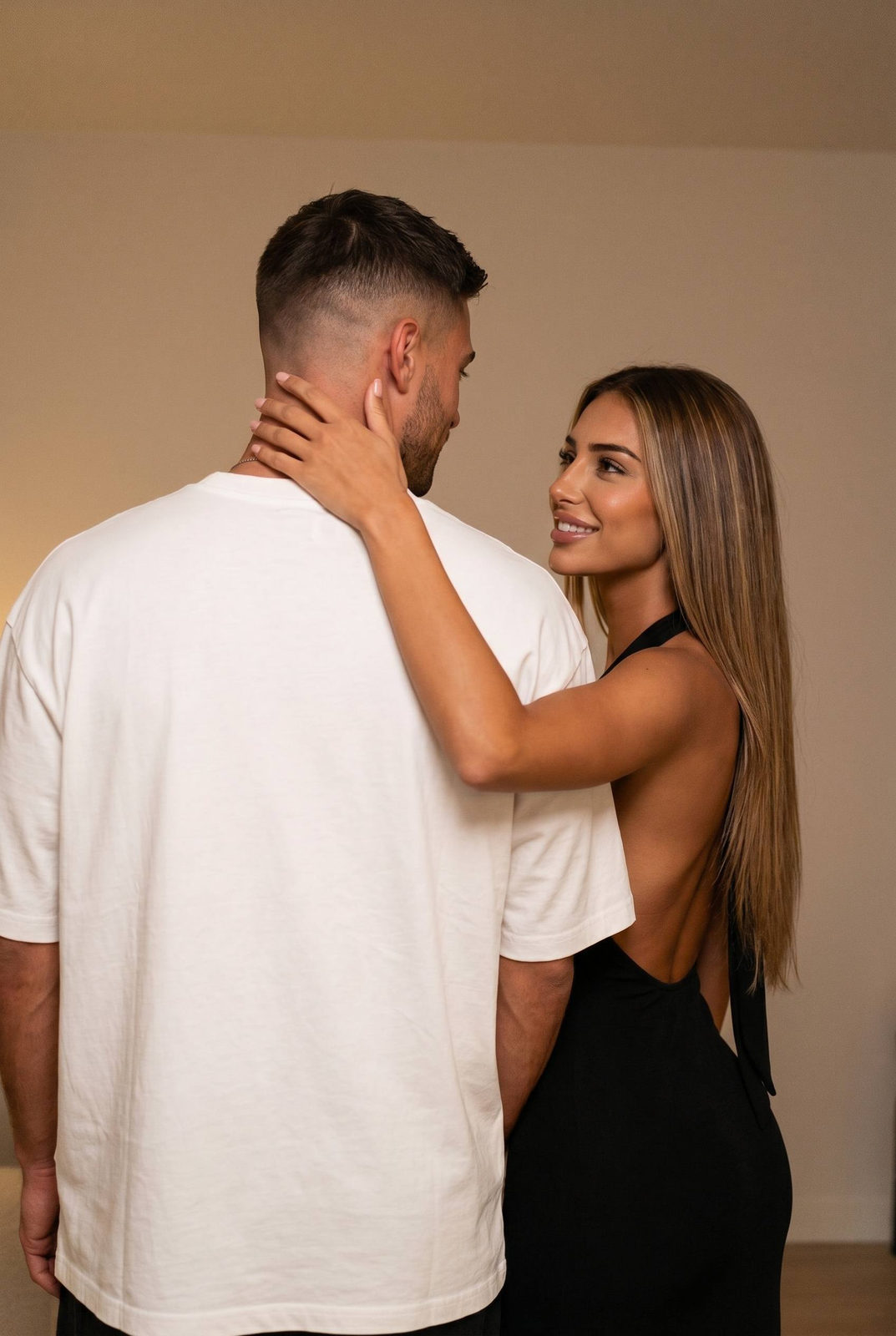 A couple indoors, man with back to camera, woman smiling