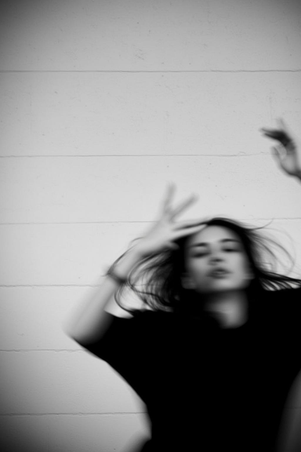 Vertical Black And White High-contrast Photograph Captures Young Woman Motion
