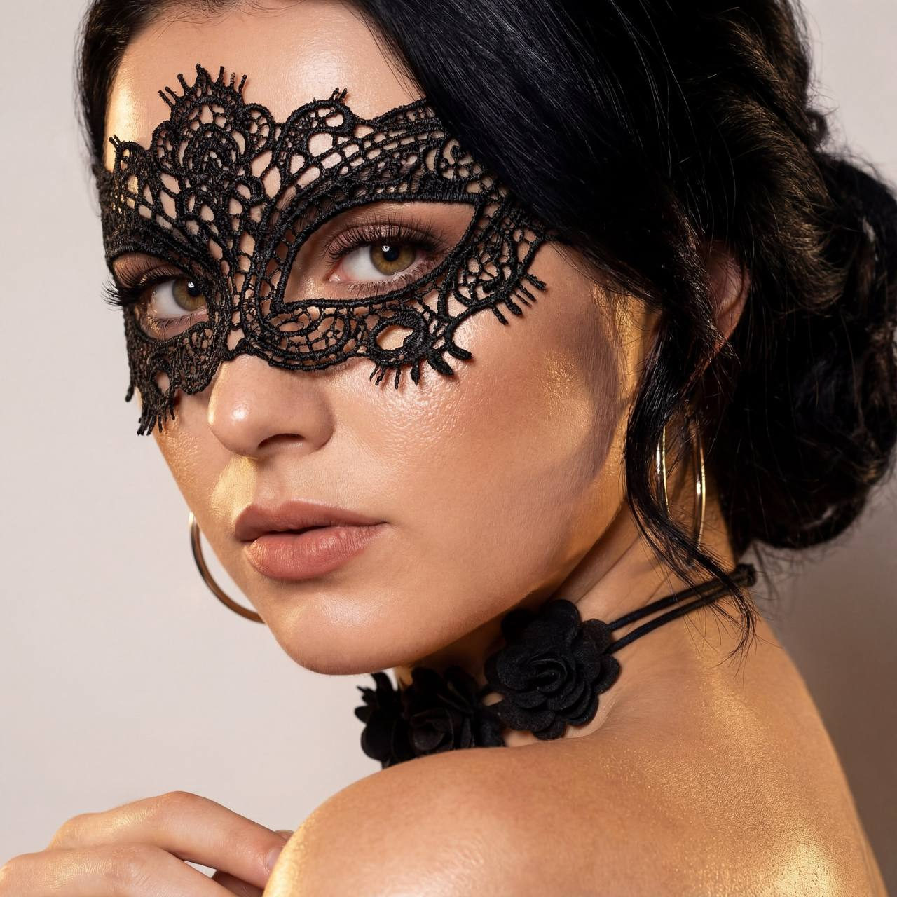 Close-up portrait of a woman wearing an elegant lace masquerade mask, showcasing intricate details and warm skin tones.
