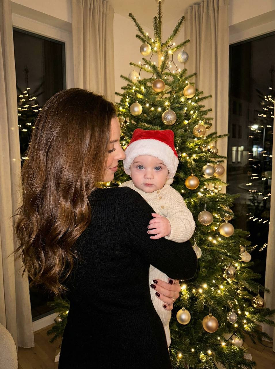 A warm festive portrait of a person holding a baby by a decorated Christmas tree, soft lights creating a cozy atmosphere.
