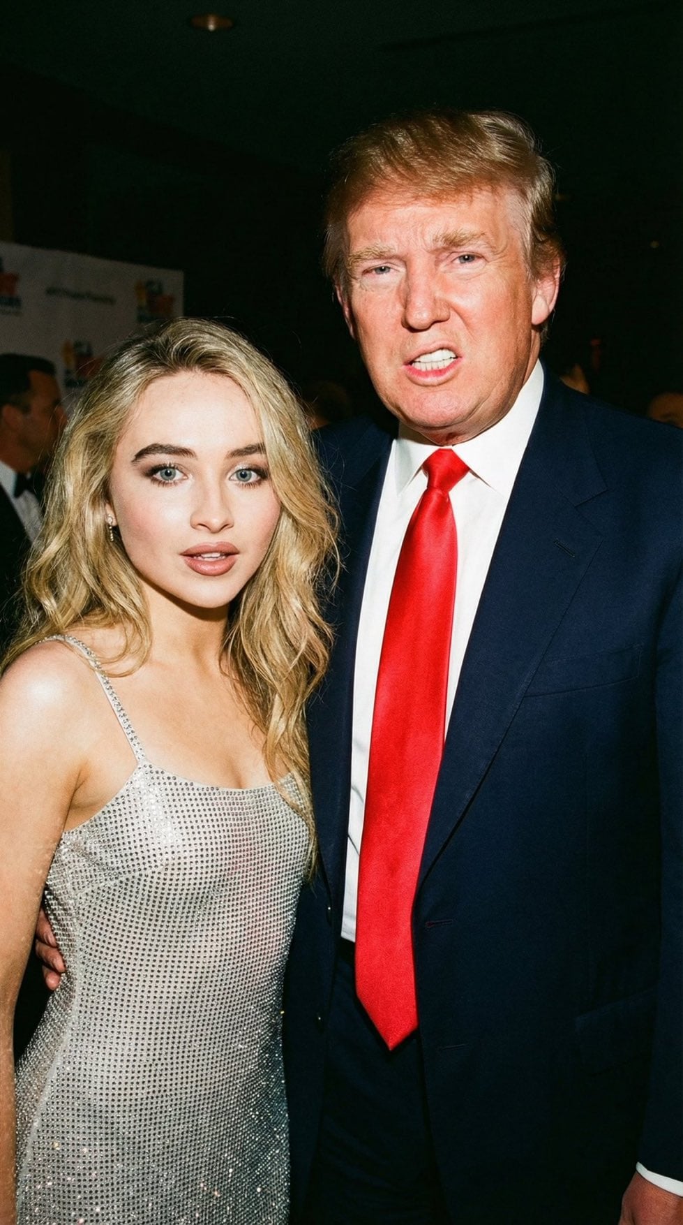 Candid portrait of Donald Trump and a woman at an evening event in a dark setting with strong flash lighting.