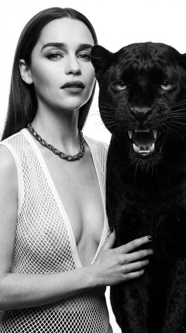 Close-up high-fashion portrait of a woman gently touching a growling panther, both captured in dramatic black and white with strong shadows.