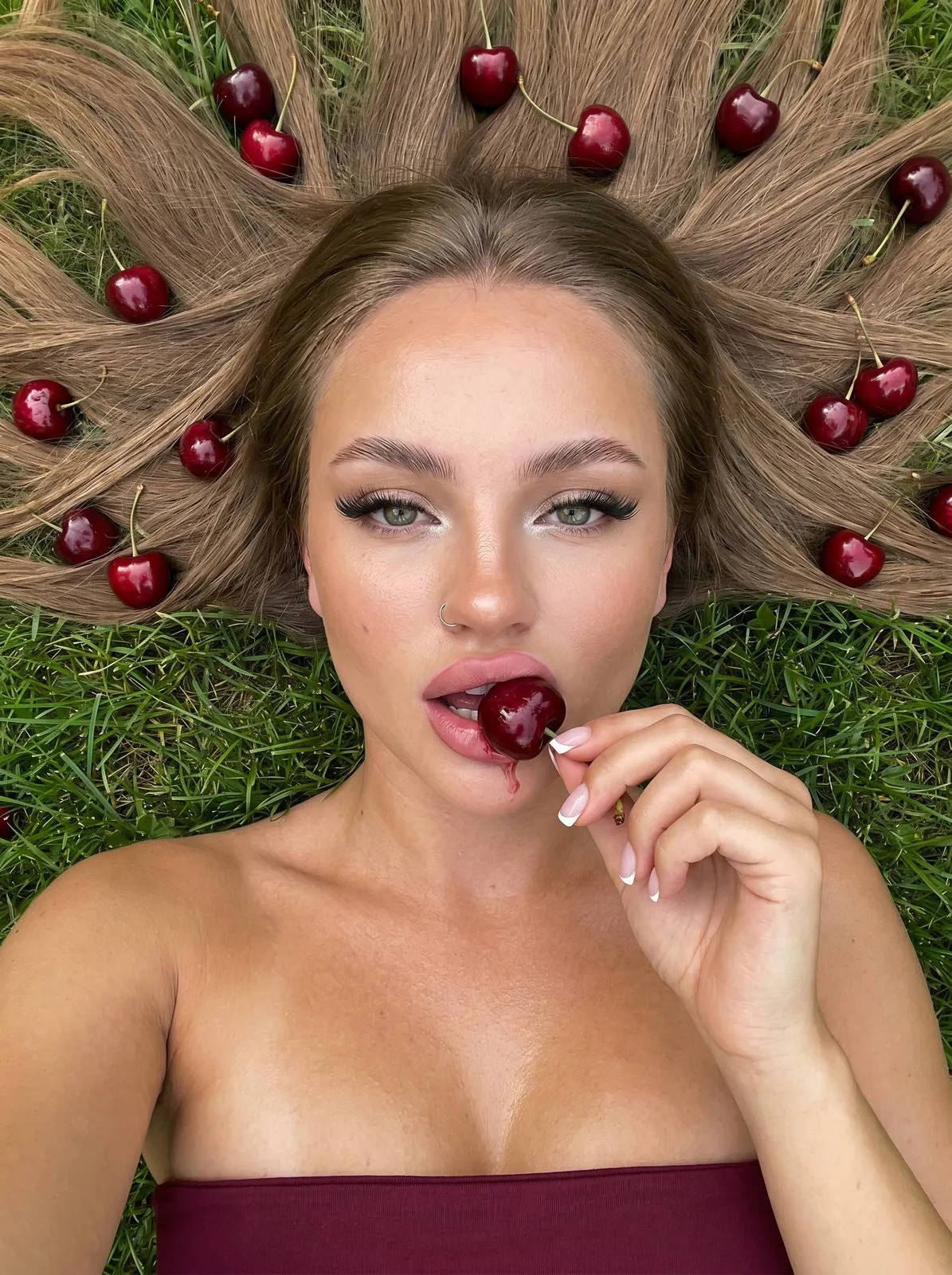 Makeup And Manicure Eating Cherries On A Green Lawn