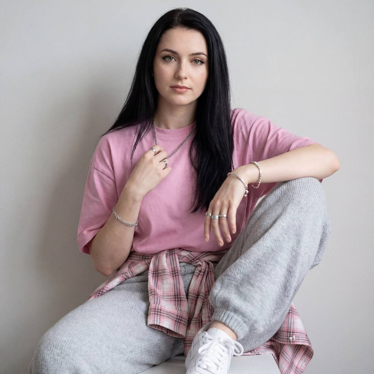 Ultra-realistic portrait of a woman in stylish street clothes, confidently gazing at the camera against a soft studio backdrop.