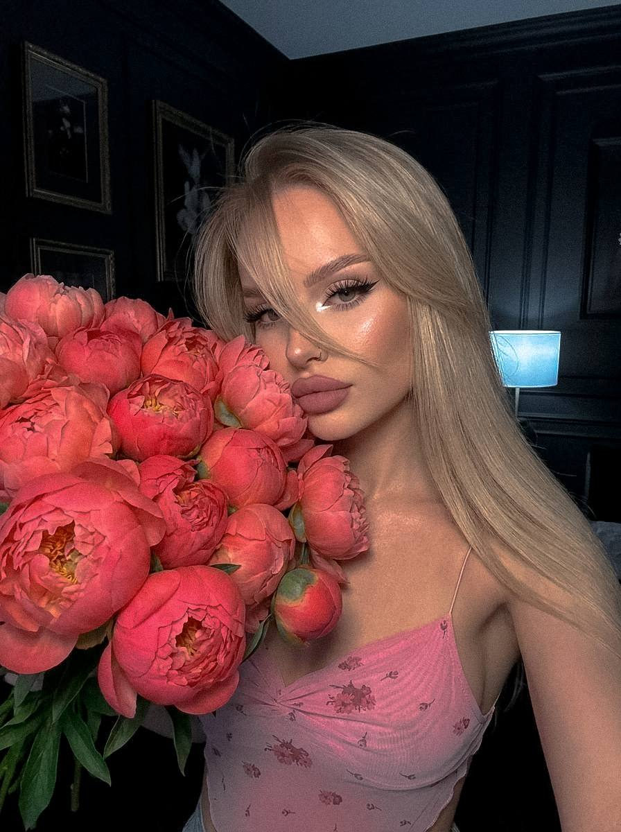 A girl with flowers covering her eye, vibrant colors and dark atmosphere.