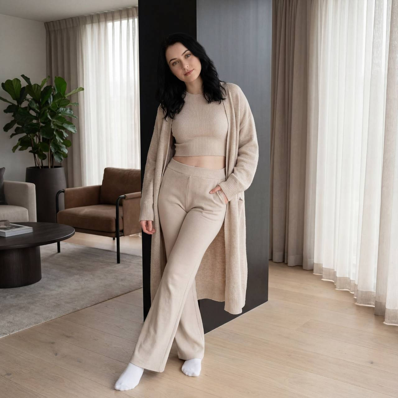 Young woman in a cozy, modern interior wearing a sporty outfit and relaxed pose, natural lighting.