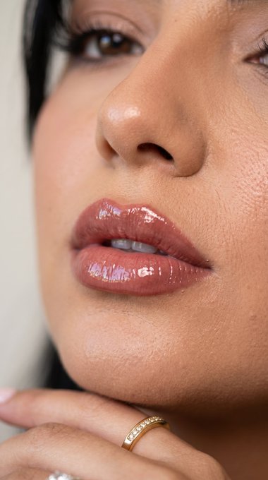 Extreme close-up of luxurious glossy lips with defined pigment and texture, offering a seductive look.