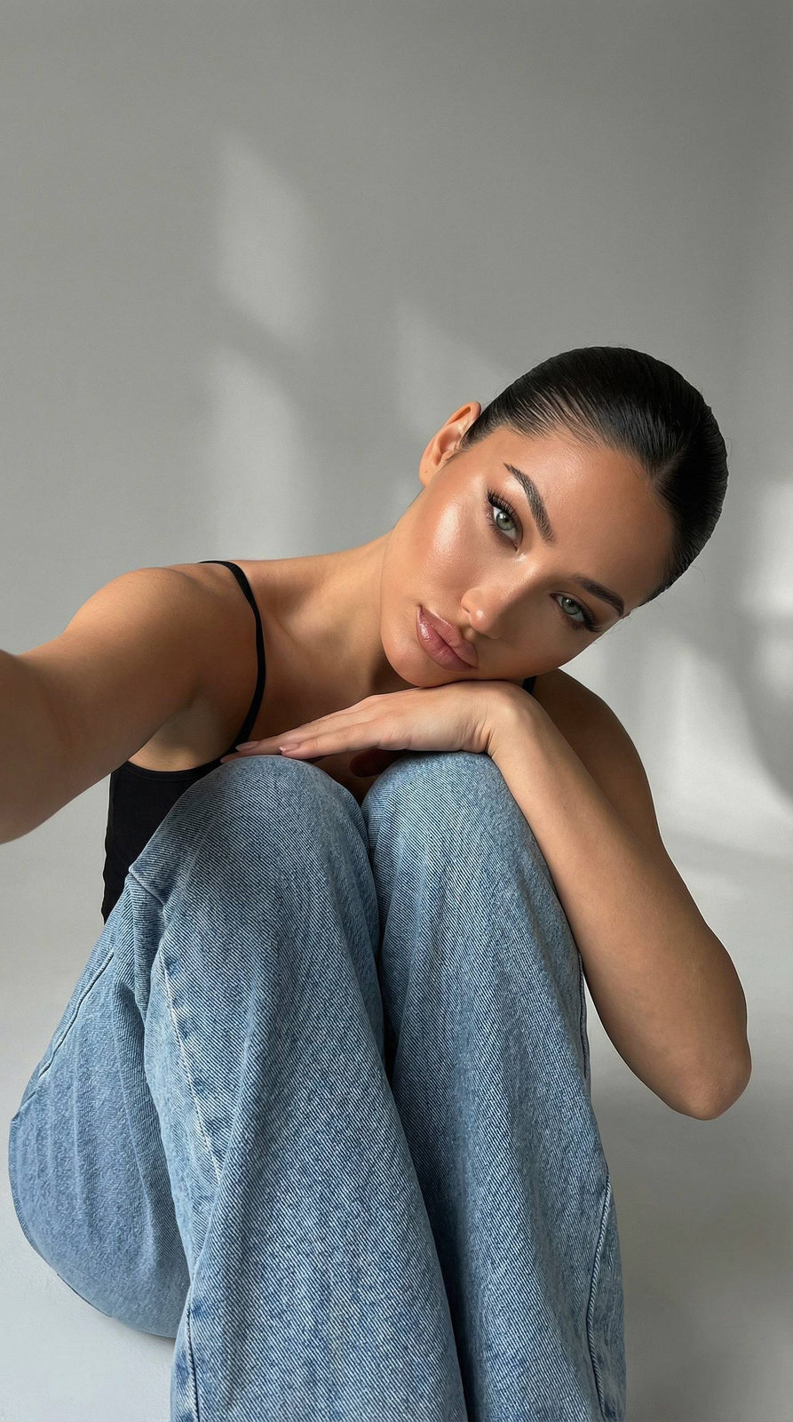 Ultra-detailed close-up portrait of a model in a low-lit studio setting, captured from a low angle, showcasing serene expression.